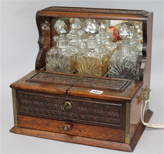 A Victorian carved oak tantalus height 32cm width 34cm